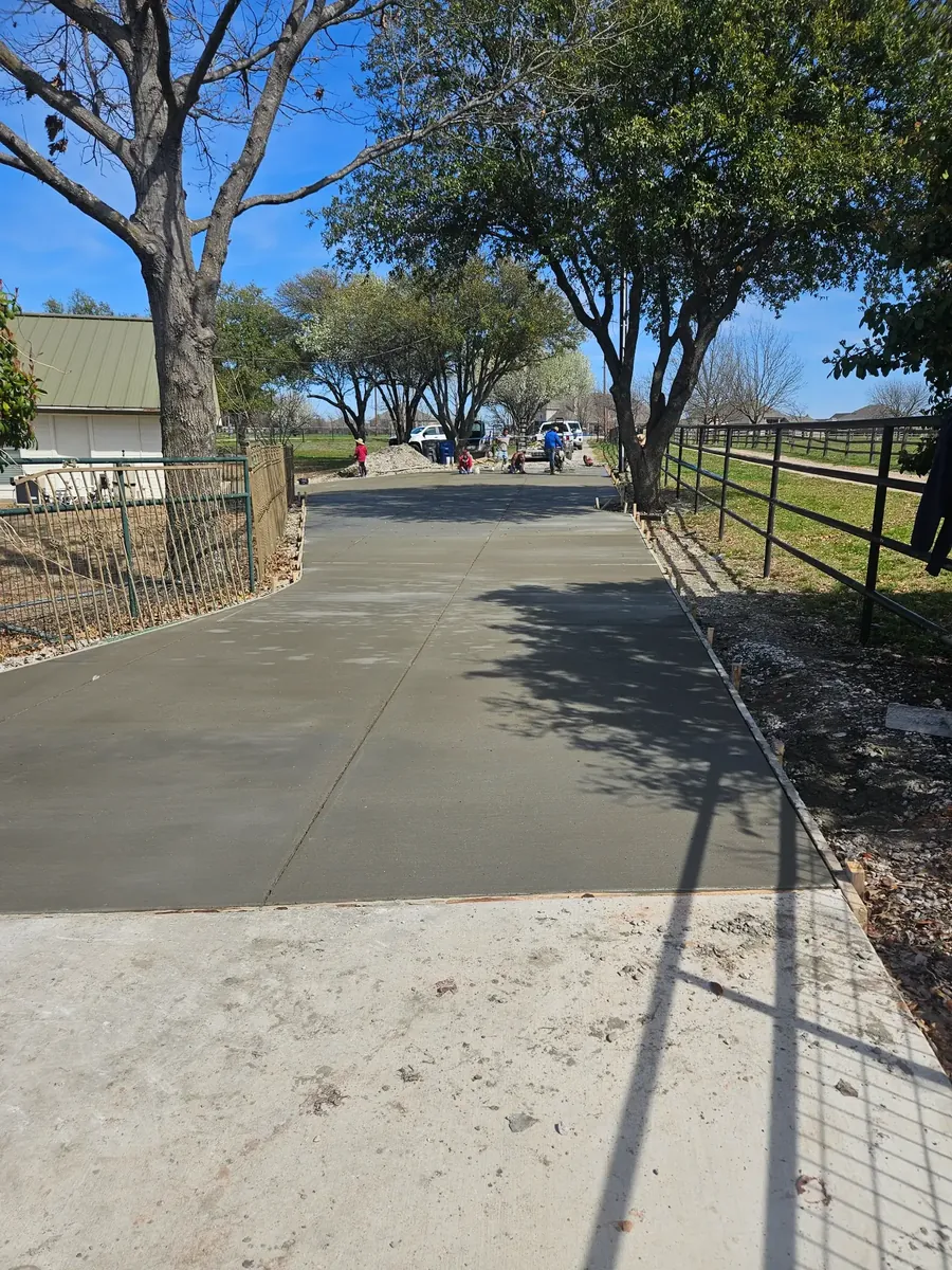 New concrete driveway along a fence line