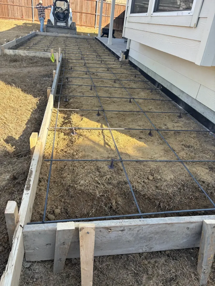 Forms and rebar set beside a home (before the pour)