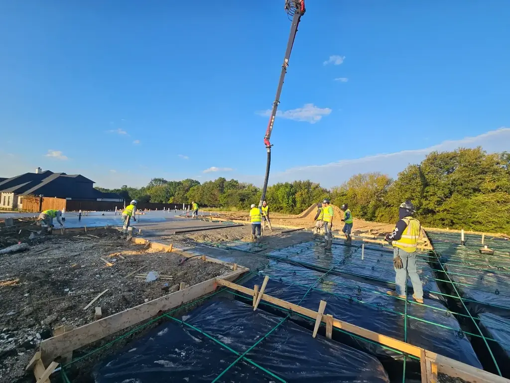 Crew placing concrete on a foundation