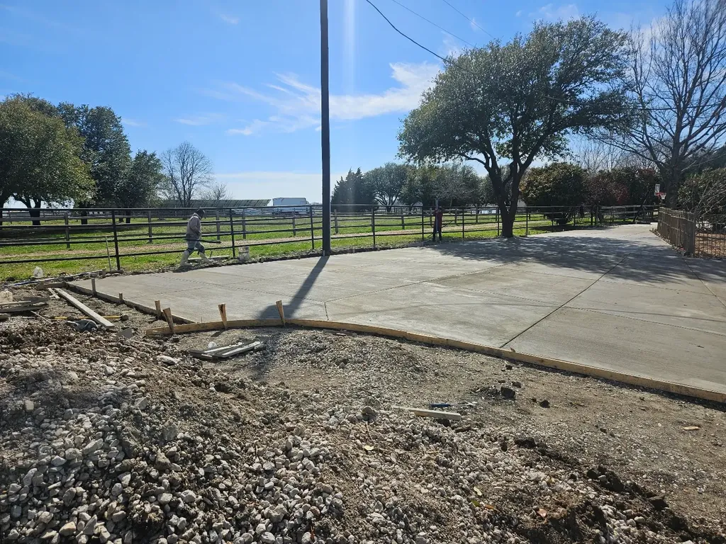 Fresh concrete pad beside a fence