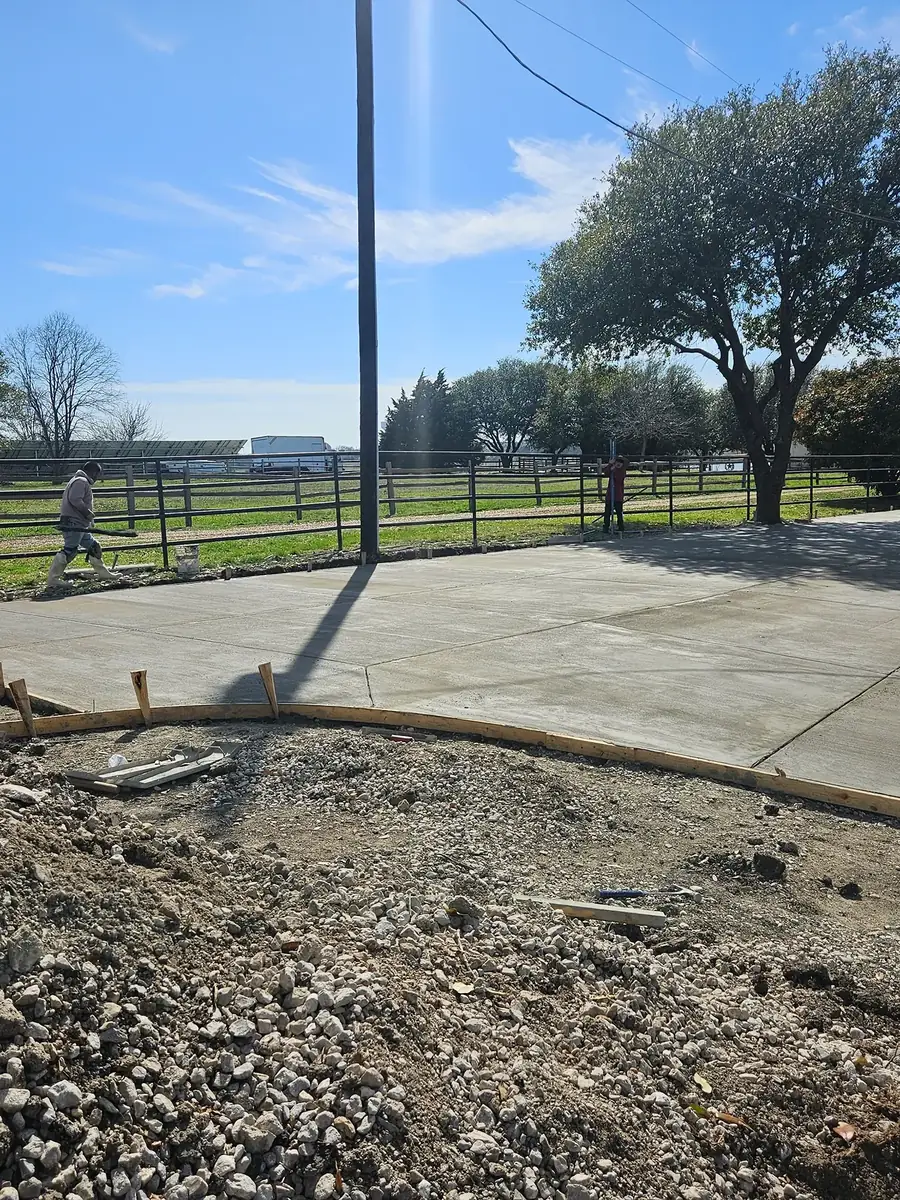 Large freshly finished concrete slab with form boards on a rural property