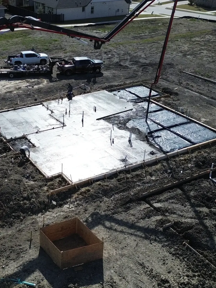 Overhead view of a slab pour with exposed rebar next to a finished section